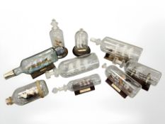 Nine glass ships in bottles, including Viking Longship, Golden Hind etc, longest 30cm.