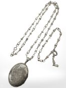 A large antique oval silver locket, upon a modern naturalistic silver chain,