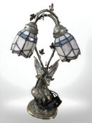 A contemporary resin table lamp depicting a fairy with Tiffany style leaded glass shades,