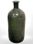 A large antique green glass bottle, height 48 cm.