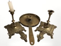 A brass pan candle holder, length 37 cm, and a further pair of cast brass candlesticks.