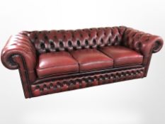 An Oxblood leather three seater Chesterfield settee,