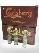 Two painted pine Carlsberg crates with glass bottles, width 48 cm.