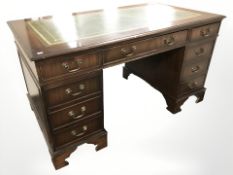A reproduction mahogany twin pedestal nine drawer desk,