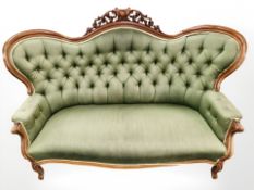 An early 20th century continental salon settee, in green buttoned upholstery,
