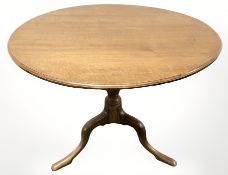A reproduction oak circular tripod table, diameter 89 cm.