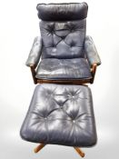 A 20th century Danish stained beech framed swivel lounge armchair in blue buttoned leather with
