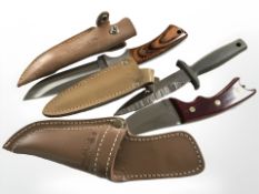 Three hunting / survival knives in leather sheathes, largest 25 cm long.