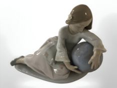 A Lladro figure of a girl leaning on a globe,