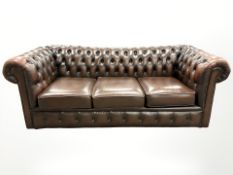 A chestnut brown leather three seater Chesterfield settee,