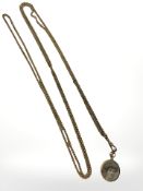 A long Victorian pinchbeck guard chain with a 9ct gold-cased photograph locket