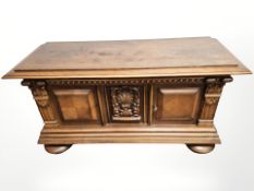 A 20th century continental carved and panelled oak low sideboard on bulbous feet,