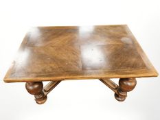 An oak pullout extending dining table on heavy bulbous legs,