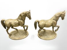 A pair of heavy cast brass cantering horse figures, height 22 cm.