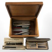 A wooden table box containing writing utensils including Conway Stewart No.
