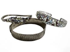 Two silver gem-set bracelets and a textured silver-gilt bracelet.