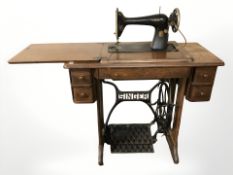 A Singer treadle sewing machine in oak table, width 87 cm.