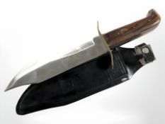 A large Bowie-style knife in black leather sheath, length 39 cm.
