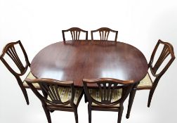 A reproduction mahogany extending table with leaf and six shield back chairs