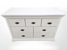 A modern white seven drawer bedroom chest, 116 cm x 50 cm x 77 cm.