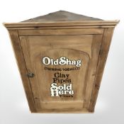 A 19th century pine hanging corner cupboard with later Old Shag tobacco painted decoration,