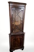 A glazed mahogany standing corner cabinet