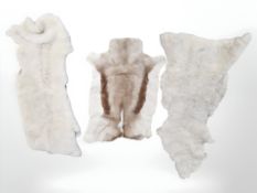 Two sheepskin rugs, a further hide rug, and a tribal spear 190cm long.