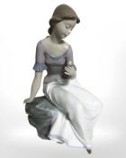 A Nao figure of a girl seated on rocks, No. 1392.