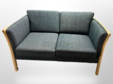 A late 20th century Danish wooden framed two seater settee in charcoal fabric,