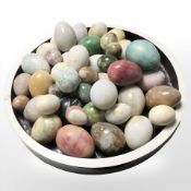 A quantity of polished stone egg ornaments.