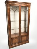 A reproduction mahogany double door display cabinet, 111 cm x 41 cm x 200 cm.