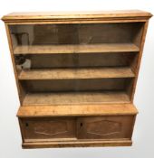 A continental stained birch sliding glass door bookcase, with cupboard beneath,
