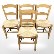 A set of four rush seated dining chairs.