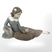 A Nao figure of a seated girl holding a rose.