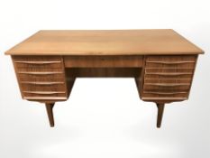 A 20th century Danish teak writing desk, fitted drawers to front and open shelves to reverse,