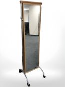 A modern teak and chrome cheval mirror on casters, height 173 cm.