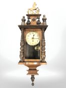 A continental walnut wall clock surmounted by a horse, height 82 cm.