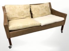 A Danish tan leather two seater settee with associated cushions, width 150 cm.