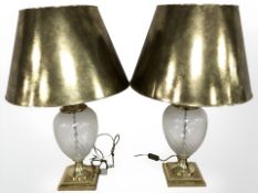 A pair of brass and glass table lamps with decorative gold coloured shades, height 79 cm.