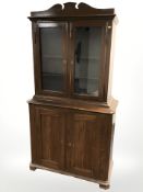 A stained pine double door cabinet, with cupboards beneath, 103 cm x 45 cm x 190 cm.
