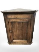 A George III oak hanging corner cabinet, height 100 cm.