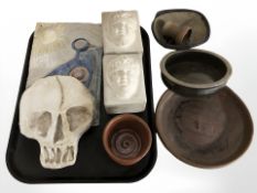 A pair of stone and plaster bookends, plaster plaque depicting a skull, earthenware dishes, etc.