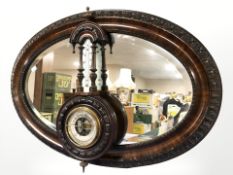 A mahogany oval bevelled mirror, width 82 cm, and a barometer.