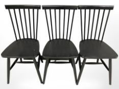 A set of three spindle back ebonised dining chairs.