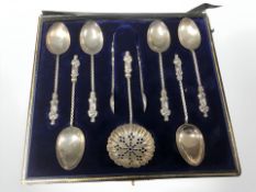 A cased set of silver apostle tea spoons, with matching straining spoon and tongs,