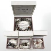 A Pandora charm bracelet with numerous charms, boxed, and three further boxed charms.
