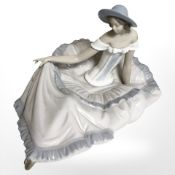 A Nao figure of a seated lady in flowing dress.