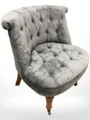 A contemporary salon chair in buttoned grey fabric.
