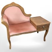 A carved telephone seat in pink draylon upholstery.