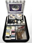 A decorative jewellery box in the form of a book containing assorted spools of thread,